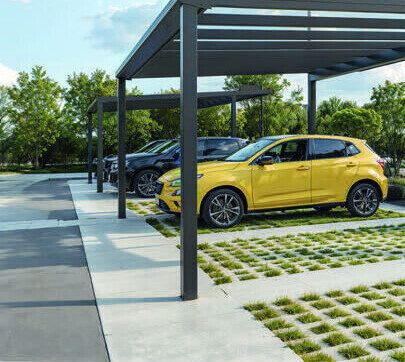 Freistehender Alu-Carport mit gelbem Auto auf Rasengittersteinen